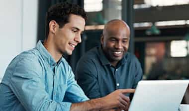 Person helping another on computer.