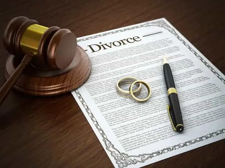 wedding bands and gavel on top of divorce document